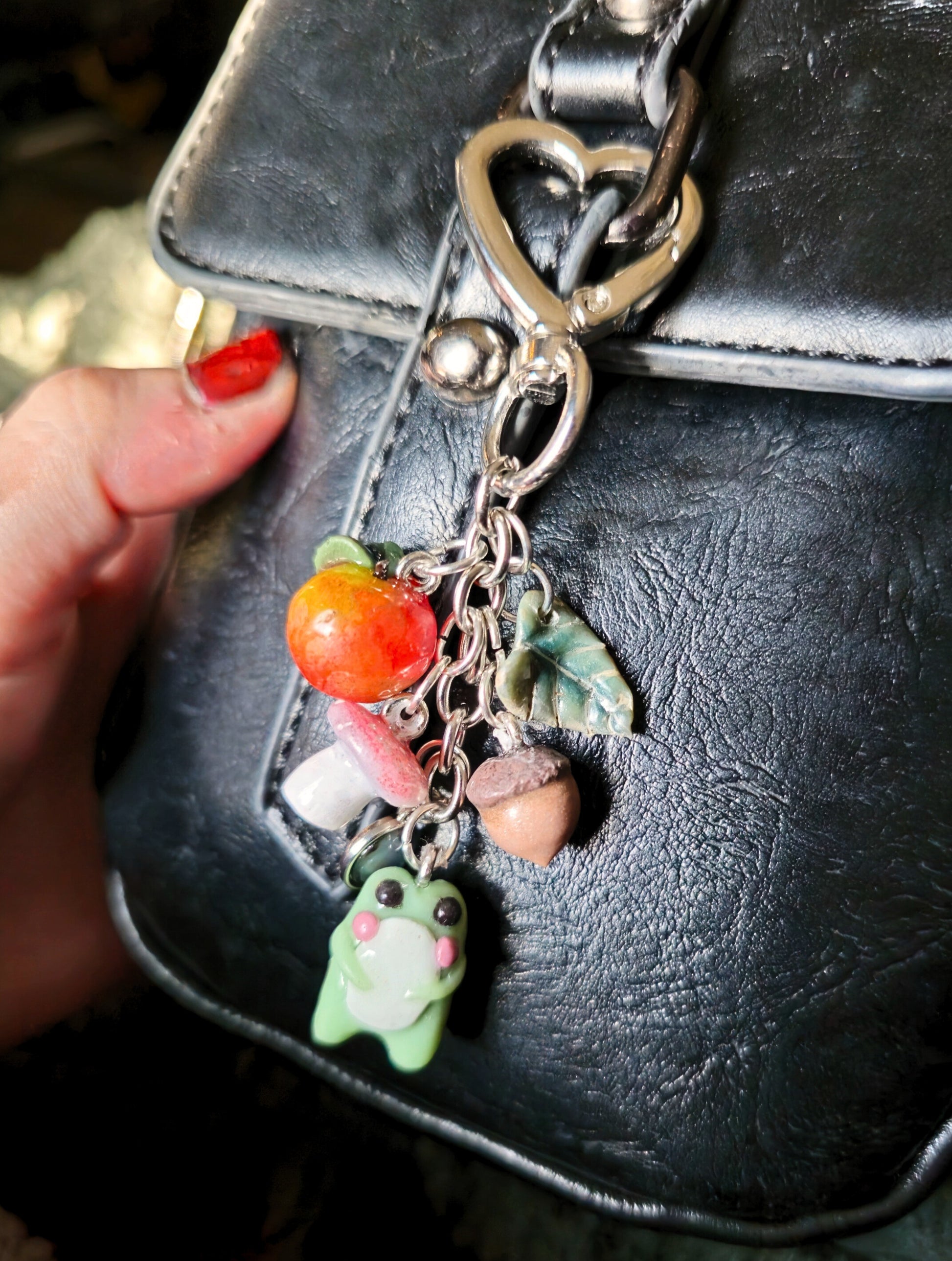 Keychain with colorful charms attached to a black leather bag.